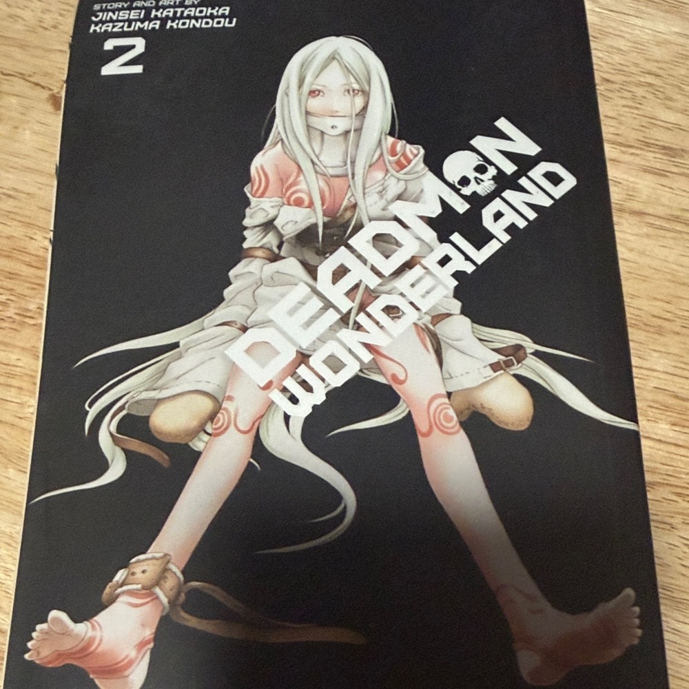 WONDERLAND Black Paperback with Silver Emblem